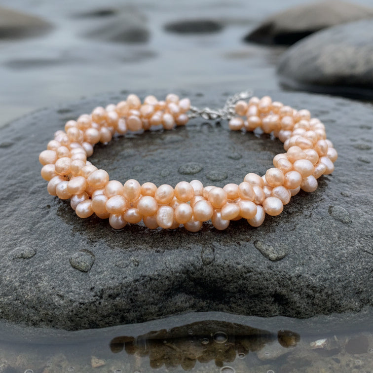 Oranje zoetwater parelketting met 3 rijen parels liggend op steen | Azina