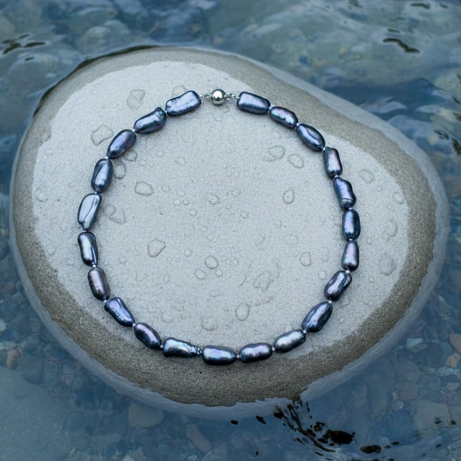 Zoetwater parelketting met bijzondere blauw zwarte parels en sterling zilver (925) liggend op steen in water | Black Princess