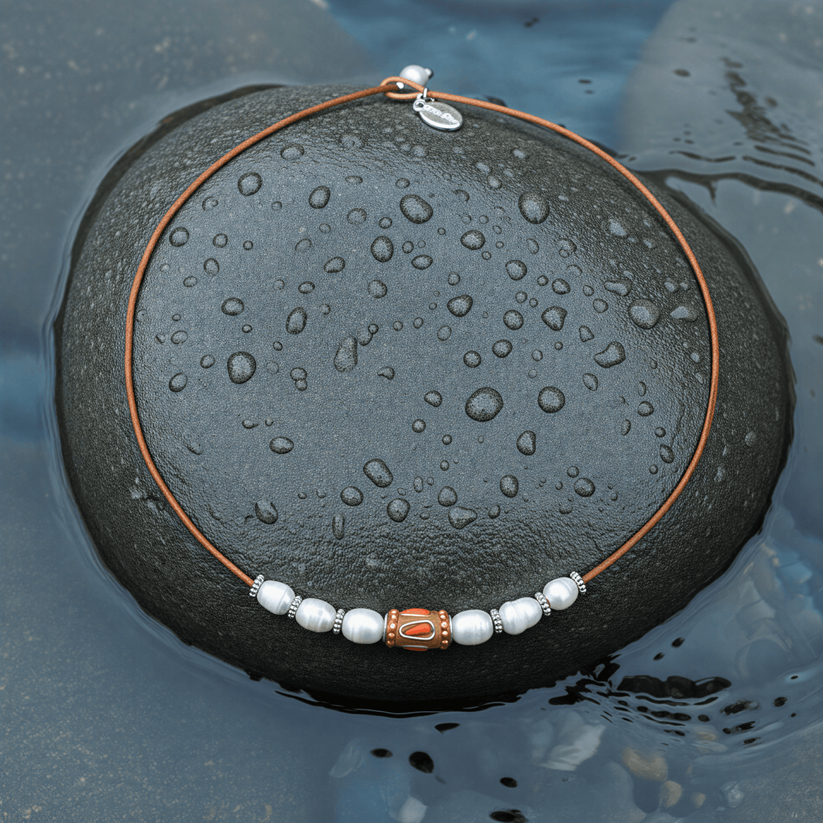 Zoetwater parelketting met echte witte parels en leer liggend op steen in water | Parelketting Ibiza Orange