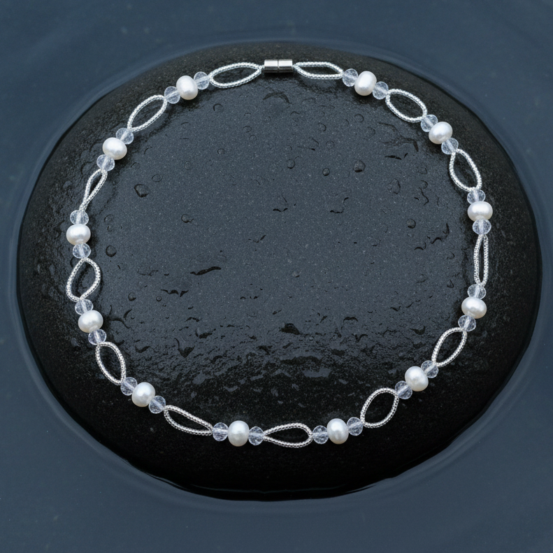 Zoetwater parelketting met witte parels en glaskristallen en magneetslot liggend op steen in water| Wicio