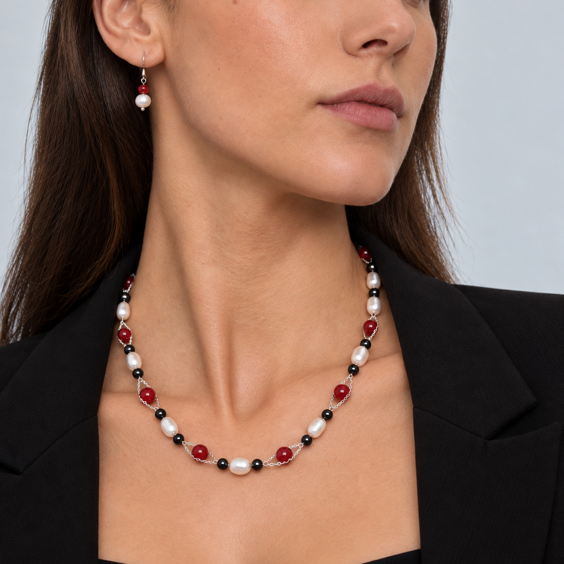 Zoetwater parelketting met magneetslot, witte parels en rode en zwarte kralen op model met zwart colbert | Santa