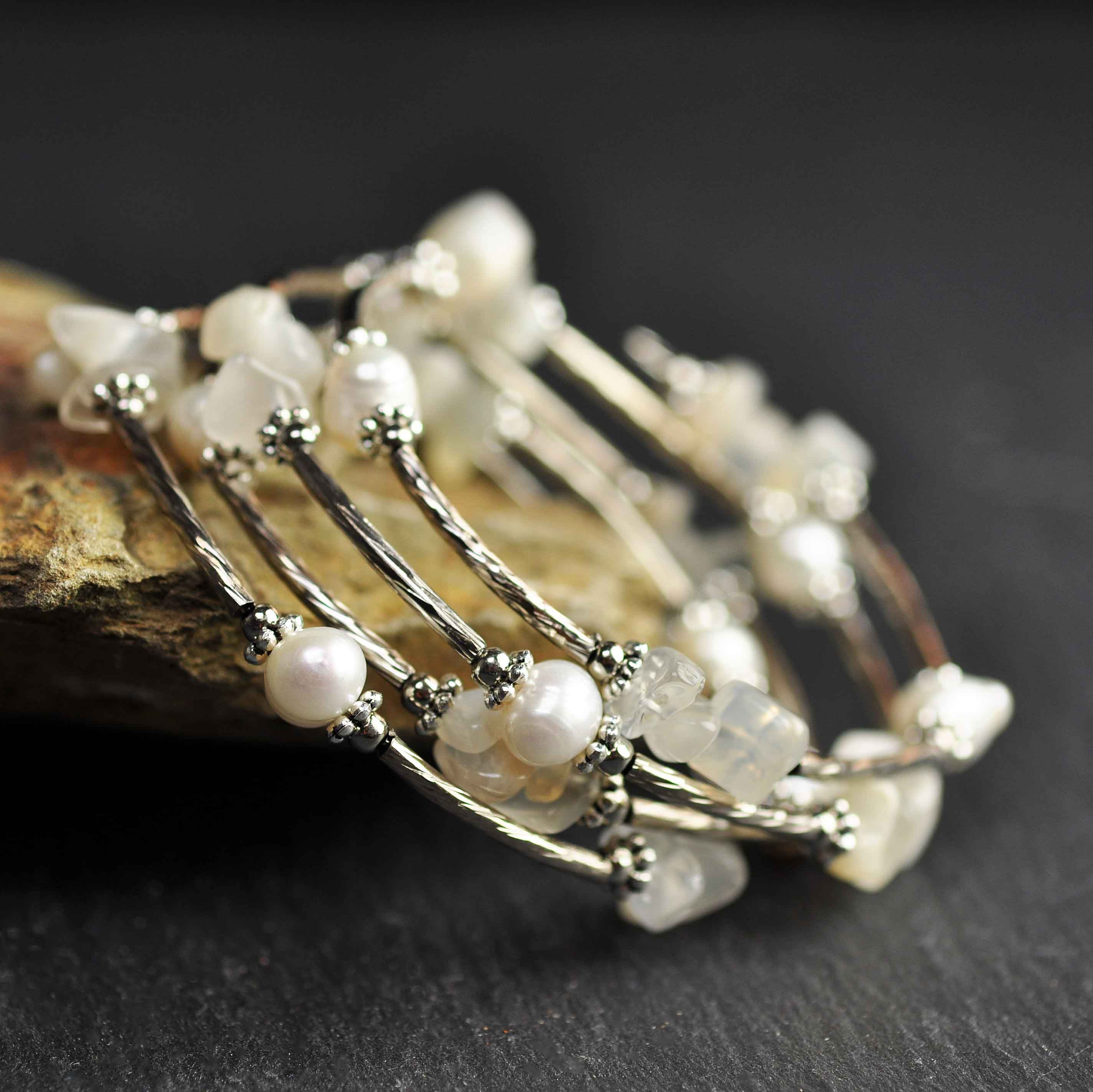 Wit zoetwater parel wikkelarmband met edelsteen maansteen en zilver liggend tegen oranje steen, zijaanzicht | Wrap Pearl Moonstone