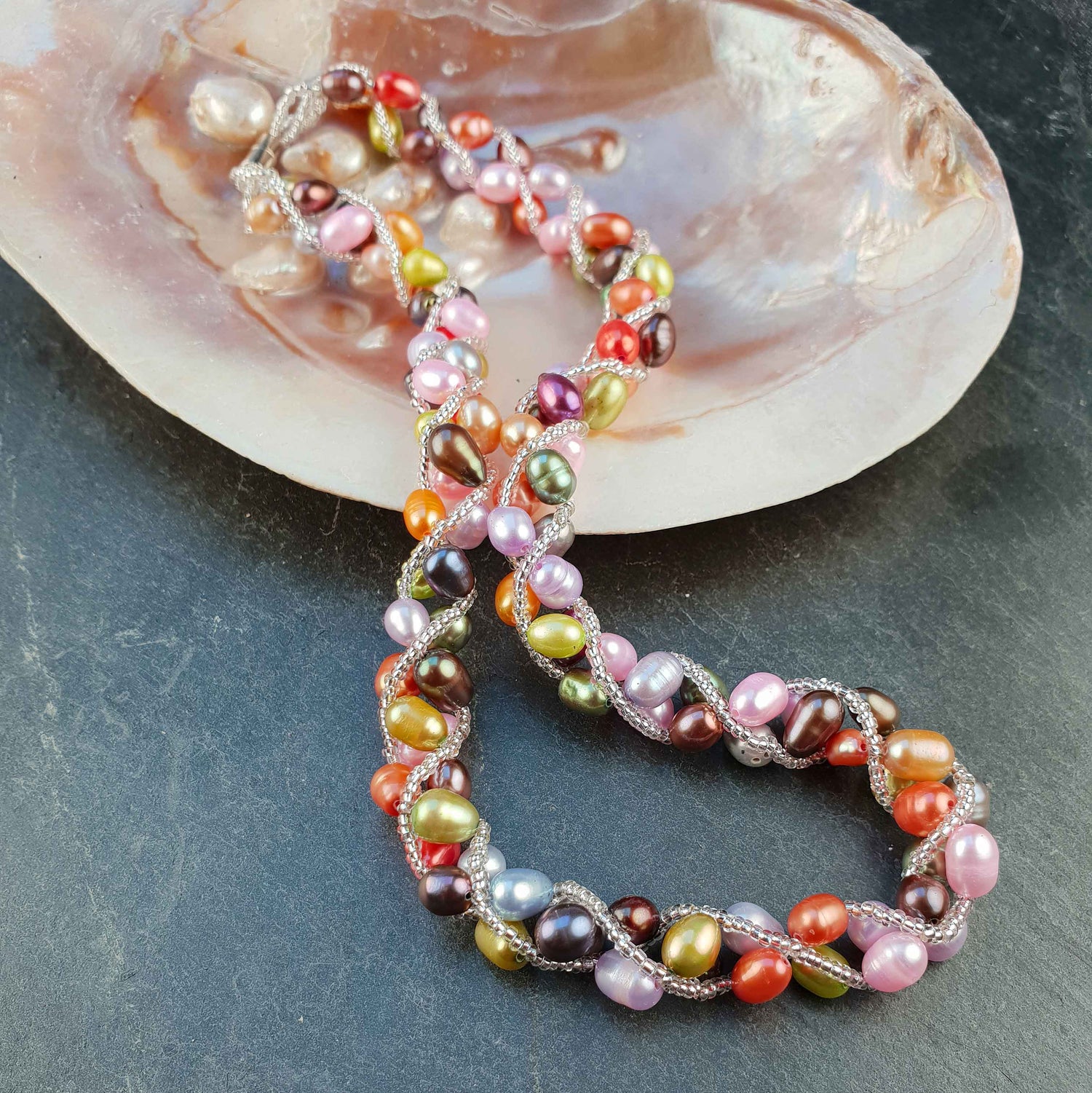 Zoetwater parelketting met vrolijk gekleurde parels en magneetslotje liggend in schelp | Bonica