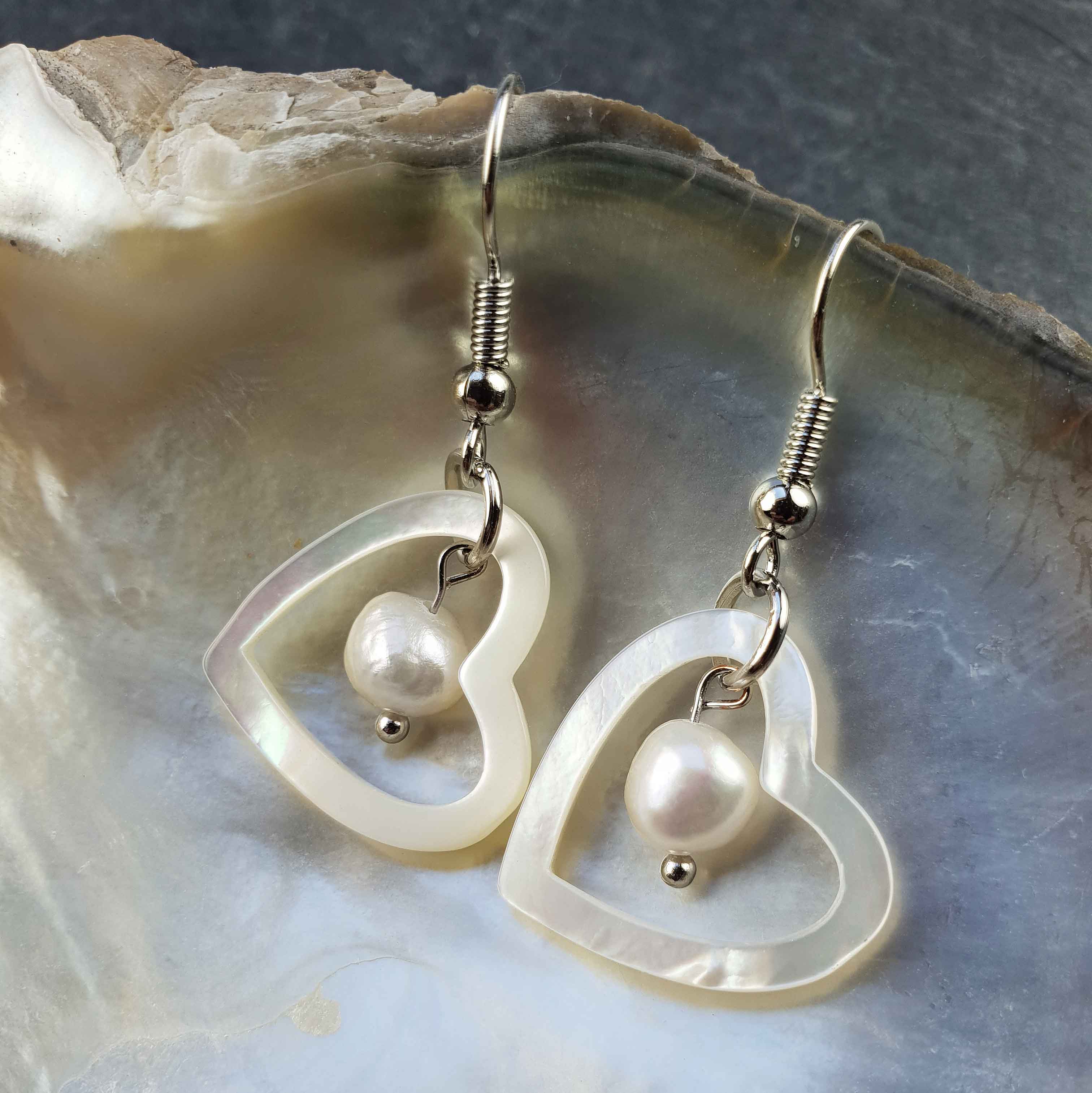 Witte zoetwater parel oorbellen met witte parel en parelmoer hart en sterling zilver (925) hangend in schelp | Pearl Heart Shell