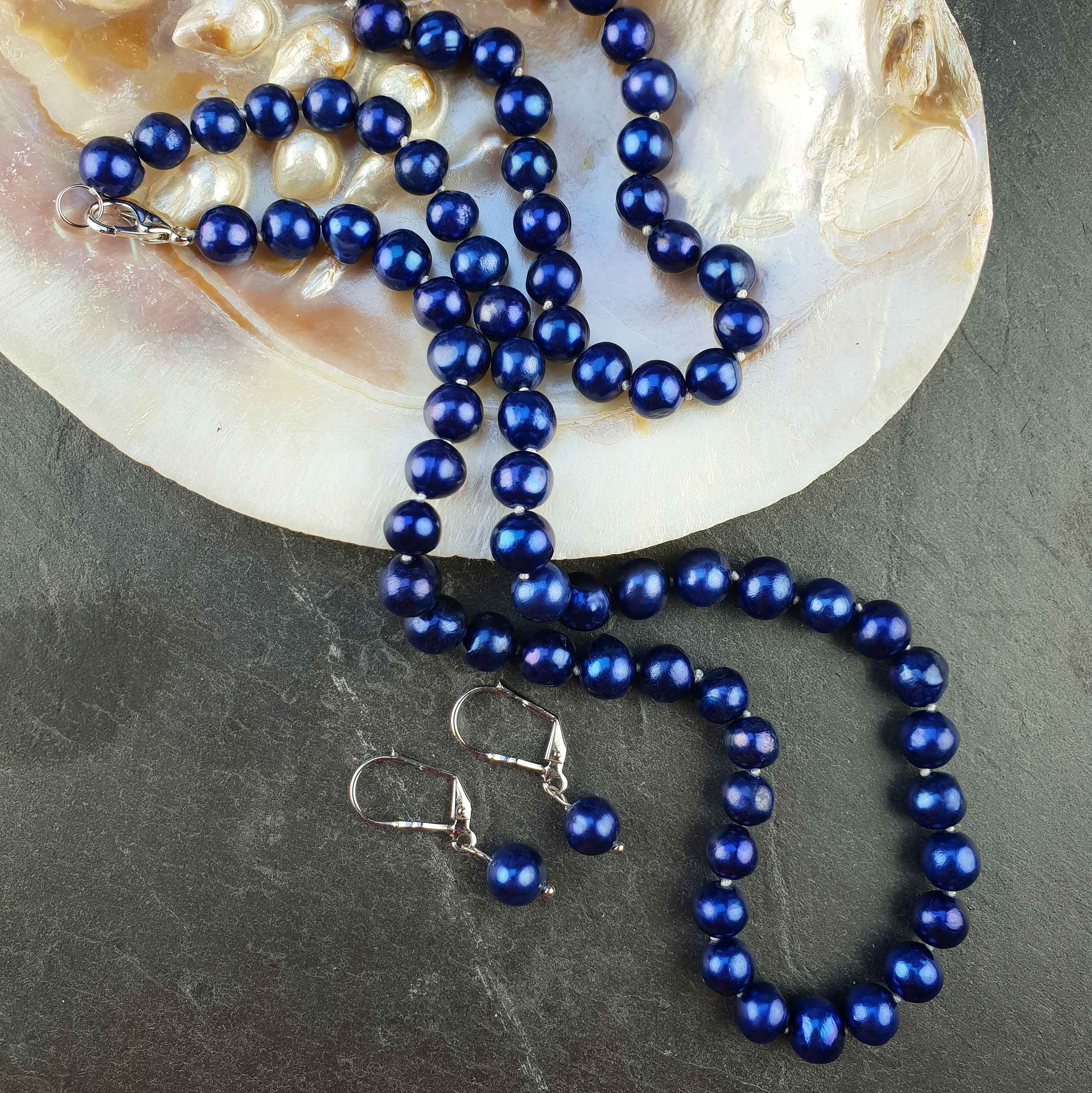 Handgeknoopte zoetwater parel set bestaande uit parelketting, parel armband en parel oorbellen met cobalt blauwe parels liggend in schelp | set Pearl Royal Blue