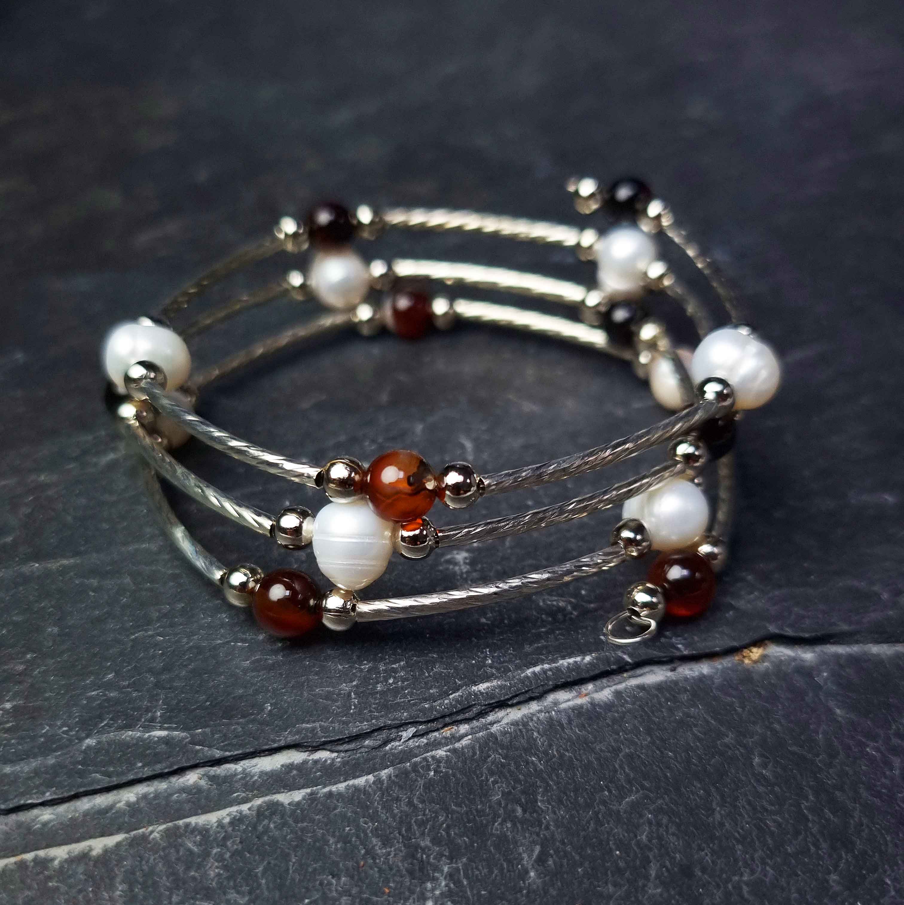 Wit zoetwater parel wikkelarmband met bruine agaat liggend op leisteen | Wrap Pearl Brown Striped Agate