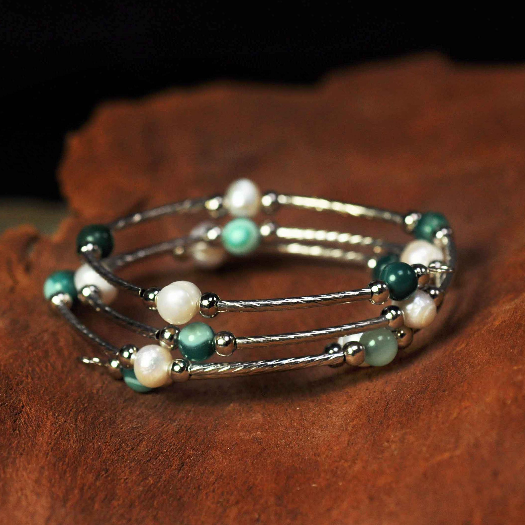 Wit zoetwater parel wikkelarmband met groene agaat liggend op hout | Wrap Pearl Green Striped Agate