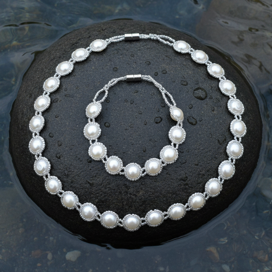 Zoetwater parel set bestaande uit parelketting en parel armband met witte parels en magneetslot liggend op steen in water | set Pearl O