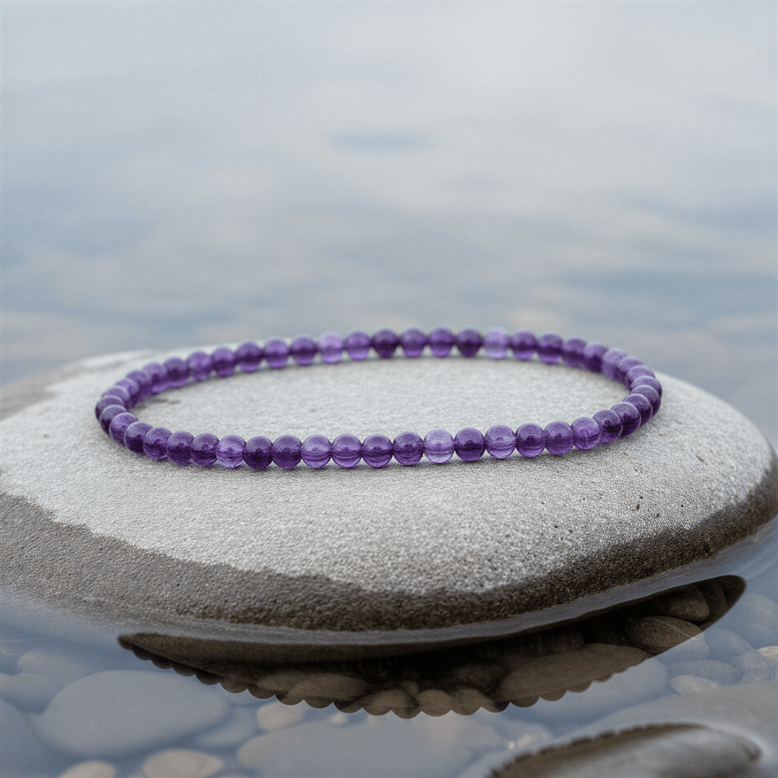 Paars edelstenen armband met amethist liggend op steen in water | Little Amethyst