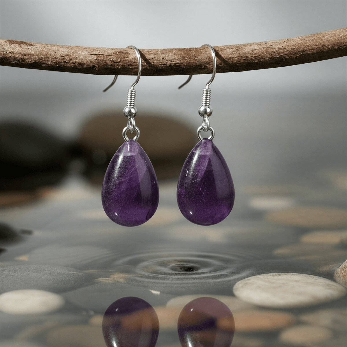Paarse edelstenen oorbellen met amethist en sterling zilver (925) hangend aan takje boven water | Amethyst Drop