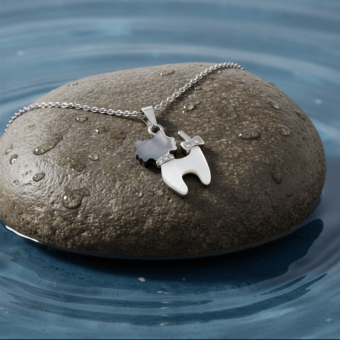 Parelmoeren ketting met parelmoeren hanger met stras steentjes in de vorm van een kat met zilver edelstaal liggend op steen | Shell Cat