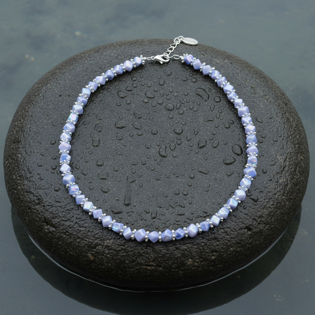 Blauw parelmoeren ketting liggend op steen | Shell Cube AB Blue