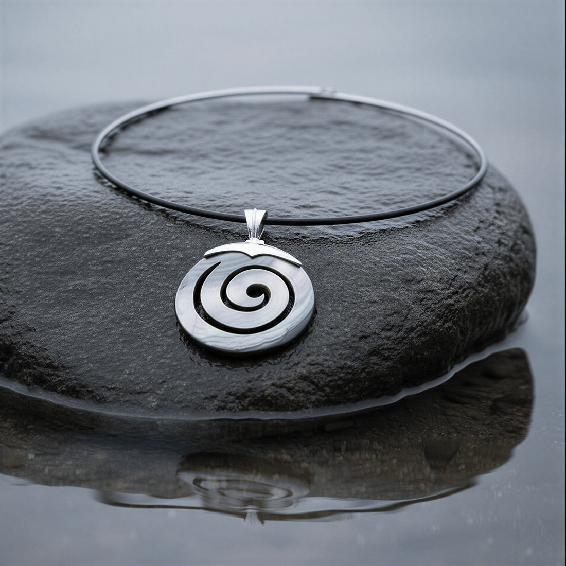 Parelmoeren choker ketting met parelmoeren hanger liggend op steen in water | Spiral Black Shell