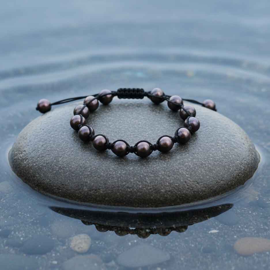 Zoetwater parel armband Sambala Brown Pearl - bovenaanzicht op steen in water