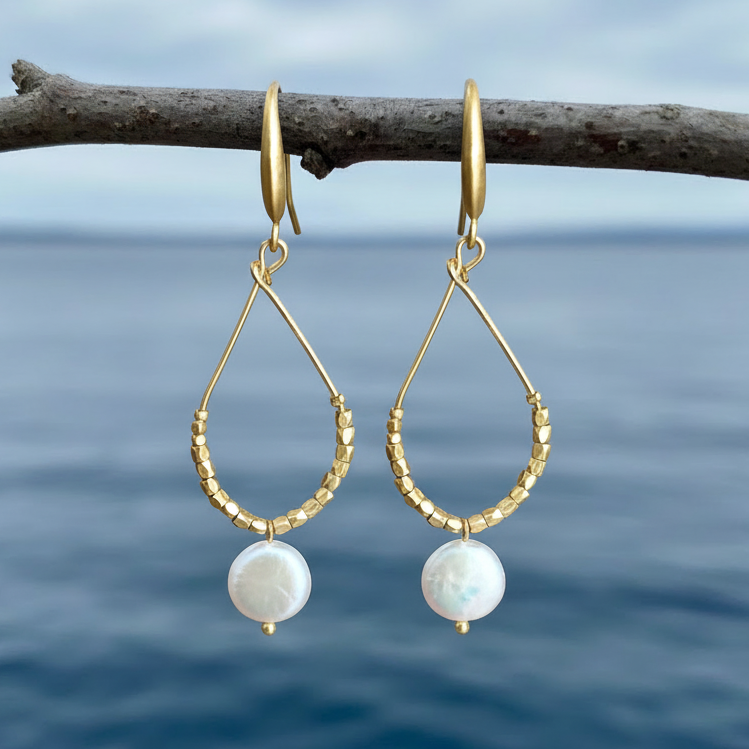 Lange witte zoetwater parel oorbellen met witte coin parels en goud hangend aan takje | Milany Gold