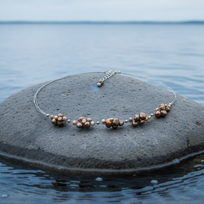 Zoetwater parelketting Browny op steen in blauw water - realistisch