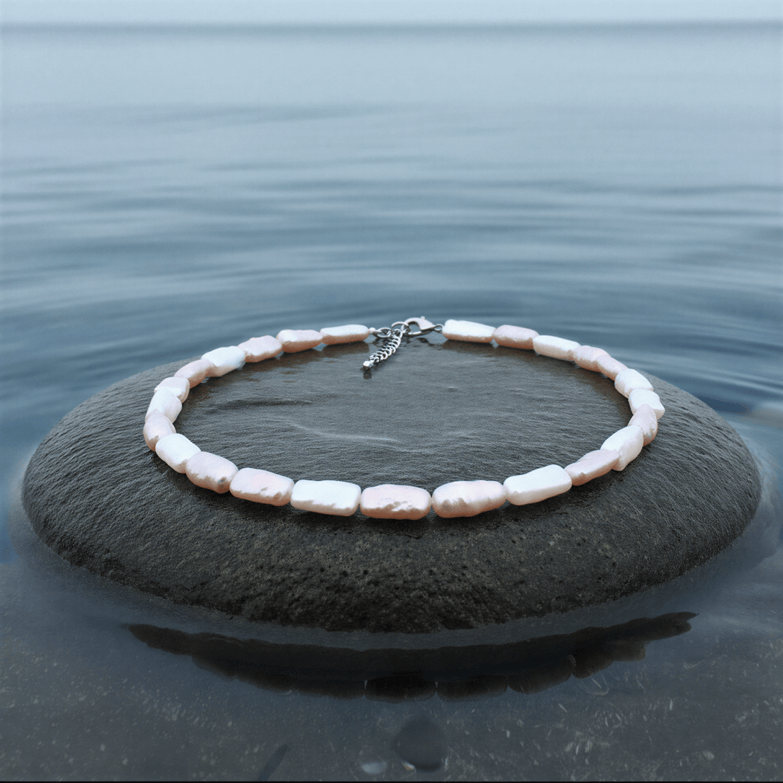 Zoetwater parelketting Pearl Rectangle Soft Colors op grijze steen blauwe waterrand