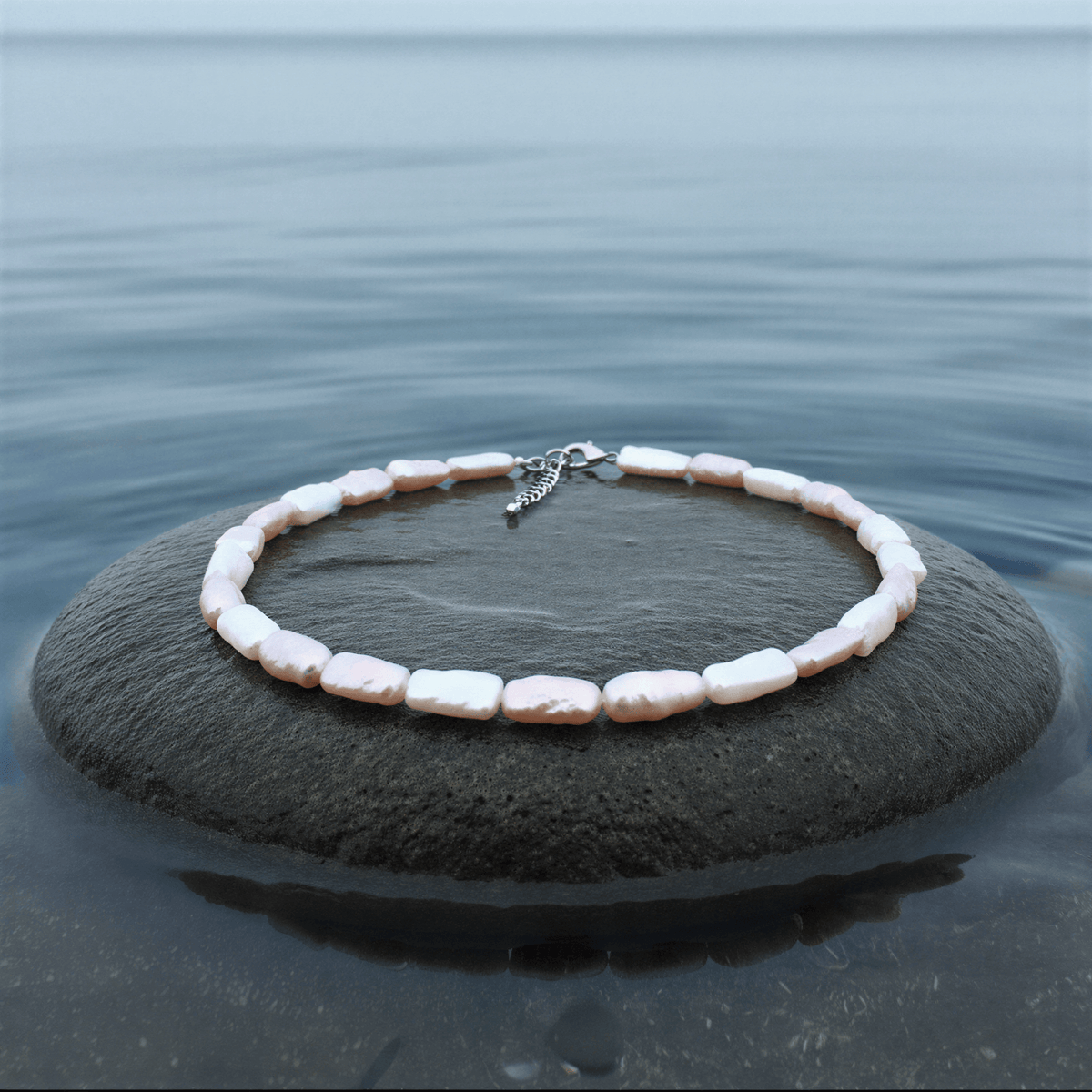 Zoetwater parelketting Pearl Rectangle Soft Colors op grijze steen blauwe waterrand
