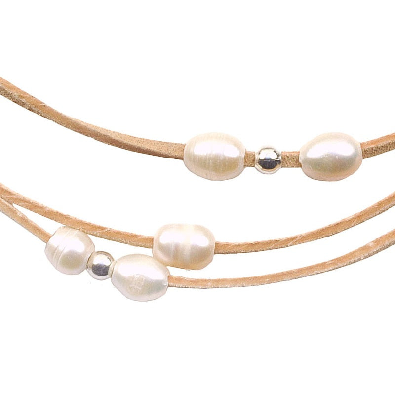 Detail van witte zoetwater parelketting met crème suede en magneetslot | set Mireille