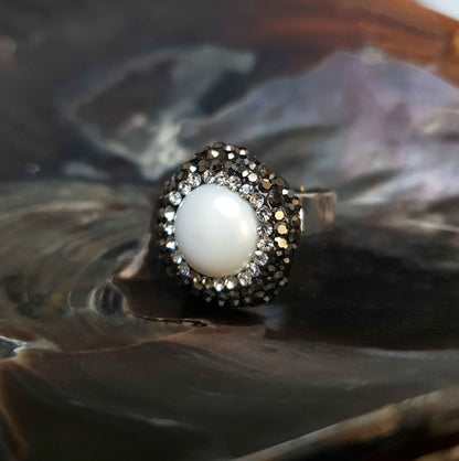 Witte zoetwater parel ring met zwarte stras steentjes liggend in schelp, aanpasbare parel ring