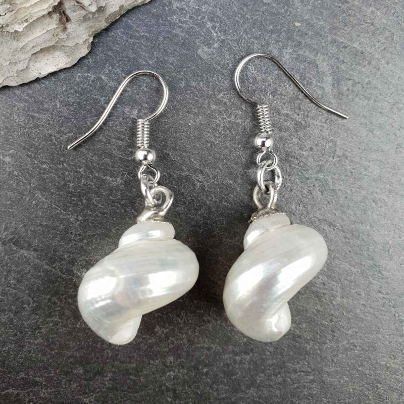 Witte schelpen oorbellen met zilver edelstaal liggend op leisteen | set Pearl White Turbo Shell