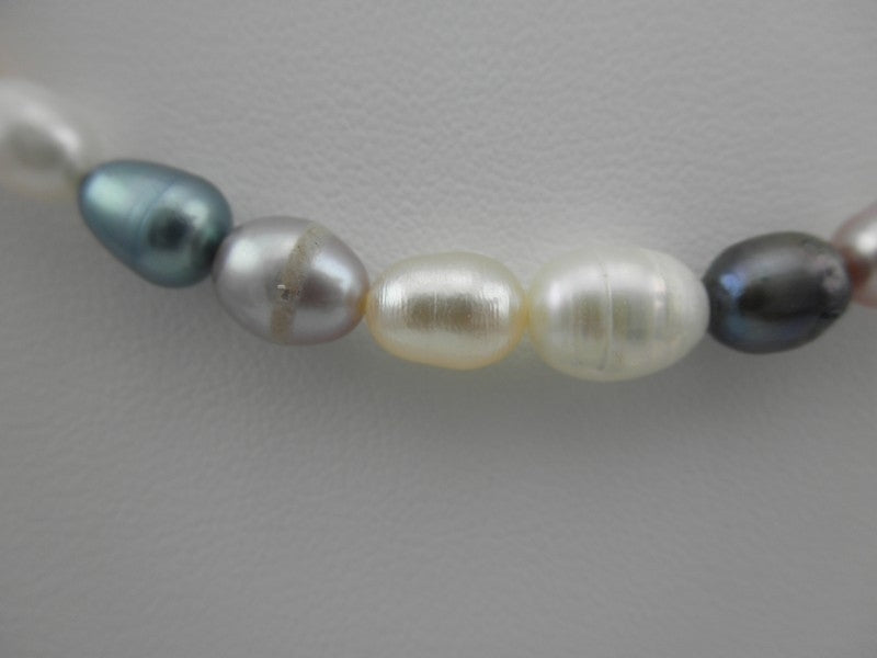Detail van handgeknoopt zoetwater parel armband met wit, zalm, roze en grijs blauwe parels en sterling zilver (925) | Sheila