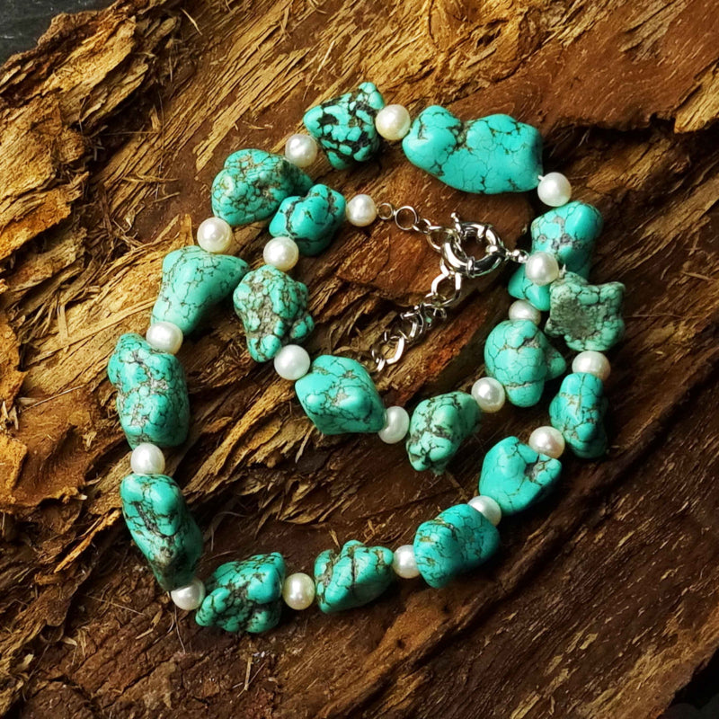 Zoetwater parelketting met witte parels en blauwe edelsteen turkoois opgerold op hout | Dominique