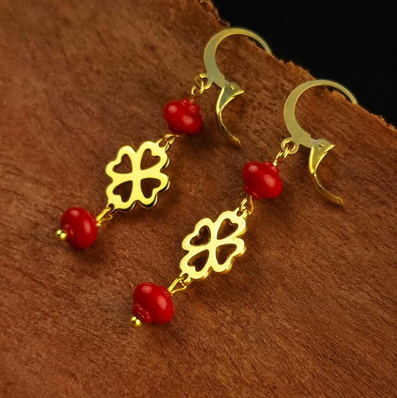 Rood koralen oorringen met goud klavertje vier van edelstaal hangend aan hout | Lucky