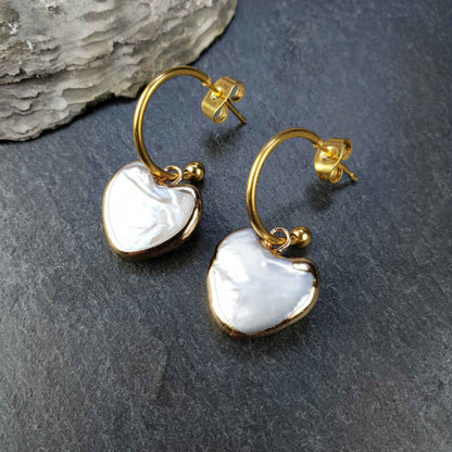 Zoetwater parel oorringen met wit parel hart en goud edelstaal liggend op leisteen | Golden Hope 15 mm Heart White Pearl