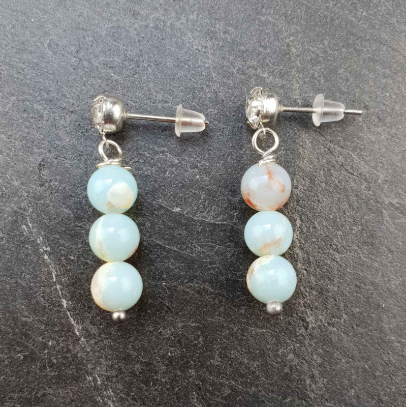 Licht blauwe edelstenen oorknopjes met shoushan en stras steentjes liggend op leisteen | Shoushan Bling