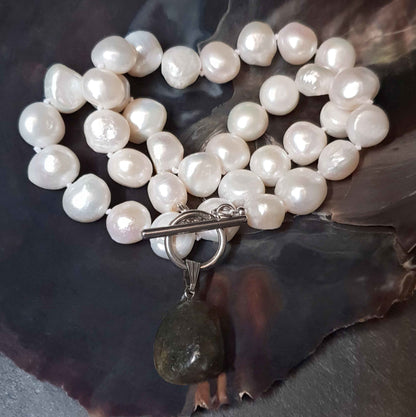 Witte zoetwater parelketting met labradoriet hanger en zilver edelstaal liggend in schelp | Toggle Big Pearl Labradorite