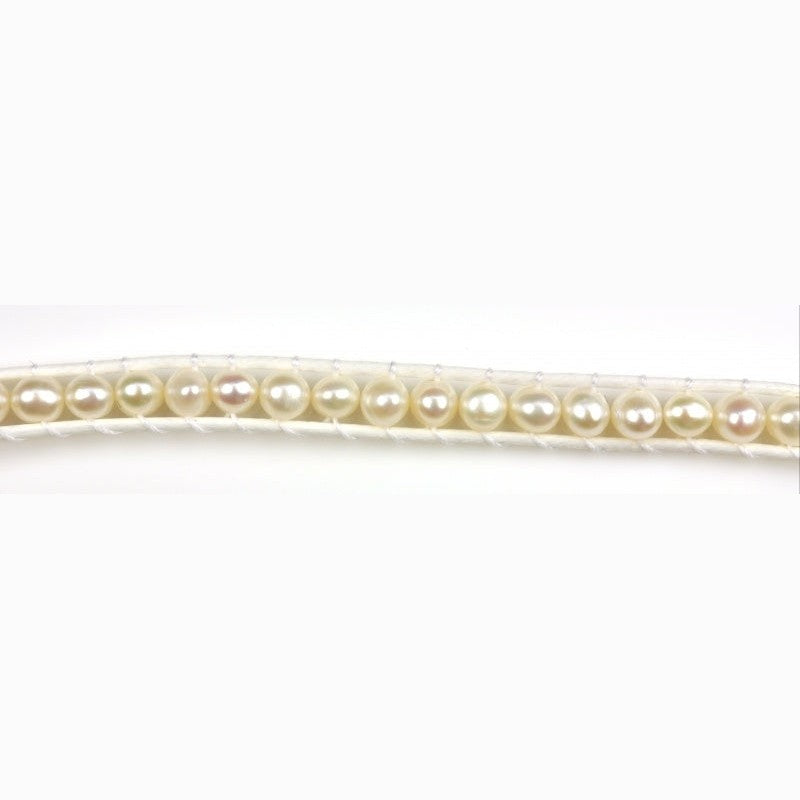 Detail van wit zoetwater parel armband geregen tussen 2 koordjes | Witney