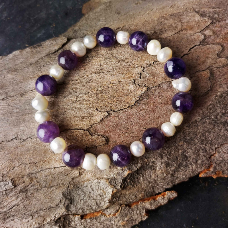 Zoetwater parel armband met witte parels en paarse edelsteen amethist liggend op hout | Pearl Amethyst