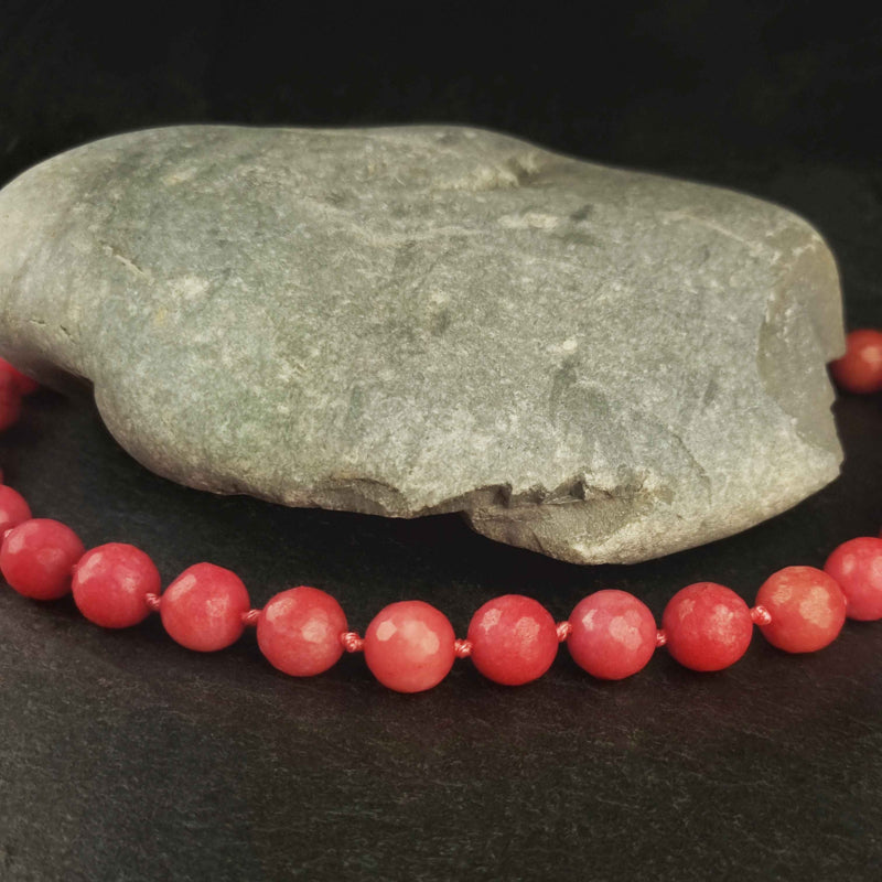 Rood roze handgeknoopte edelstenen ketting met rhodoniet en sterling zilver (925) liggend op leisteen | Facet Rhodonite Ball