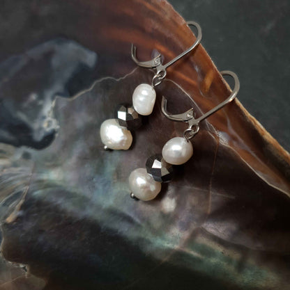 Zoetwater parel oorbellen met witte parels, zilver facet geslepen glaskristallen en zilver edelstaal hangend in schelp | Silana