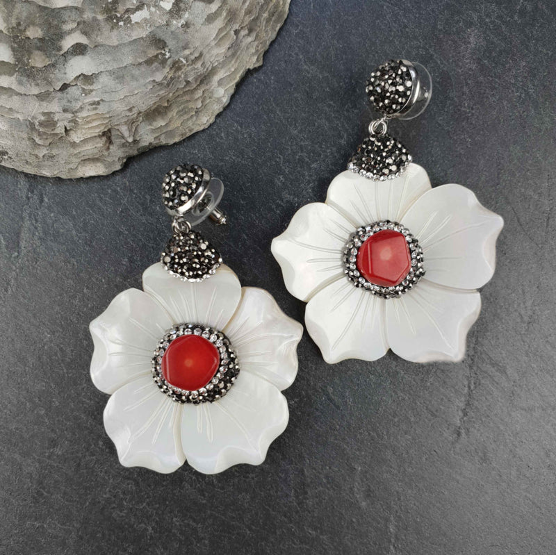 Koralen oorbellen met wit parelmoer bloem en stras steentjes liggend op leisteen | Bright Coral Flower