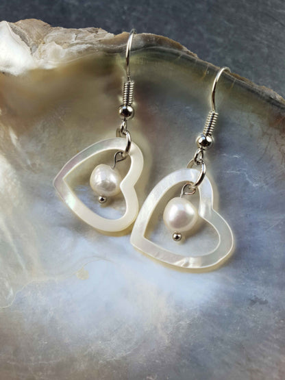 Witte zoetwater parel oorbellen met witte parel en parelmoer hart en sterling zilver (925) hangend in schelp | Pearl Heart Shell