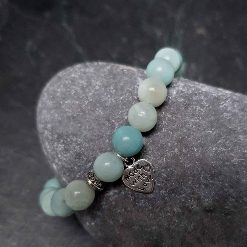 Detail van groene edelstenen armband met amazoniet en een Boeddha liggend op kei | Elastisch | Buddha Amazonite