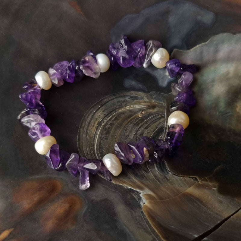 Wit zoetwater parel armband met paarse edelsteen amethist, elastisch parel armband liggend op schelp | Pearl Amethyst Chip