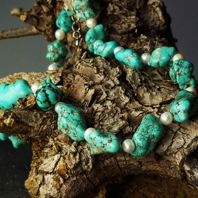 Zoetwater parelketting met witte parels en blauwe edelsteen turkoois liggend op hout | Dominique