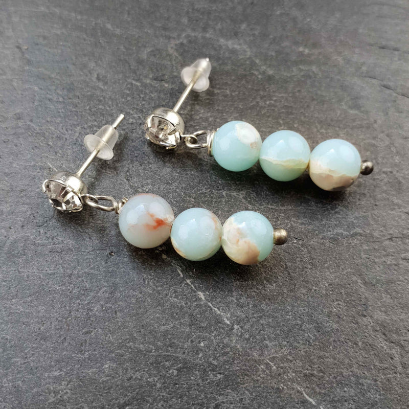 Licht blauwe edelstenen oorknopjes met shoushan en stras steentjes liggend op leisteen zijaanzicht | Shoushan Bling