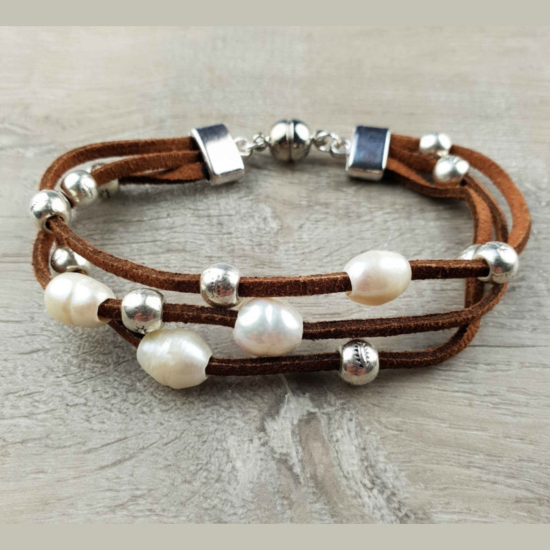 Wit zoetwater parel armband met bruin leer en magneetslot met achtergrond hout | Aafke