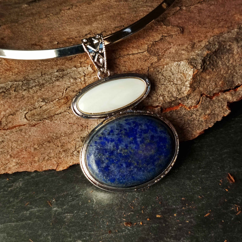Blauwe edelstenen ketting met lapis lazuli en wit parelmoeren hanger liggend tegen schors | Lapis Lazuli & White Shell