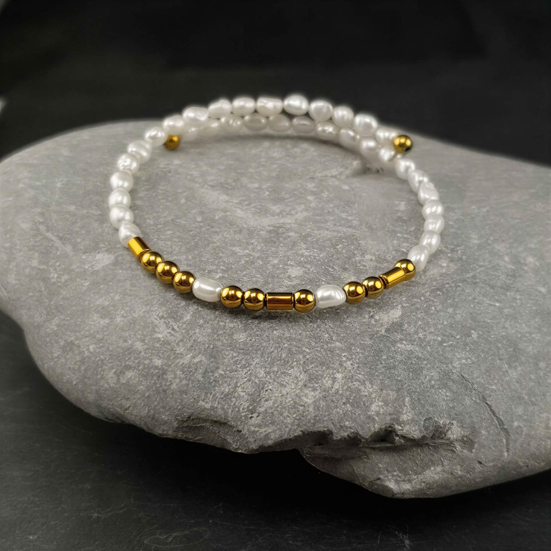 Wit zoetwater parel wikkelarmband met edelsteen goud hematiet liggend op kei | Cadeau set zoetwater parel armband Morse Code BFF Pearl Gold