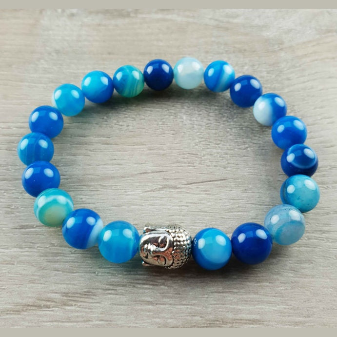 Blauwe edelstenen armband met blauwe lace agaat en zilver kleurige boeddha liggend op hout | Buddha Blue Lace Agate