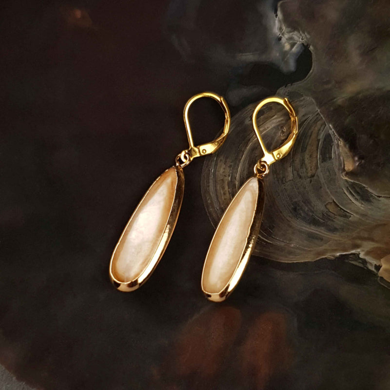Beige parelmoeren oorbellen met goud kleurig edelstaal liggend in schelp | Oblong Drop Beige