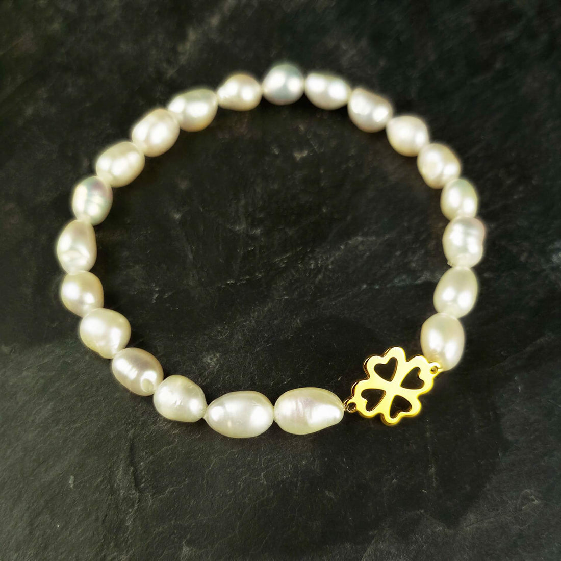 Wit zoetwater parel armband met een klavertje 4 van goud edelstaal met achtergrond leisteen | Good Luck Groot Klavertje 4 Goud