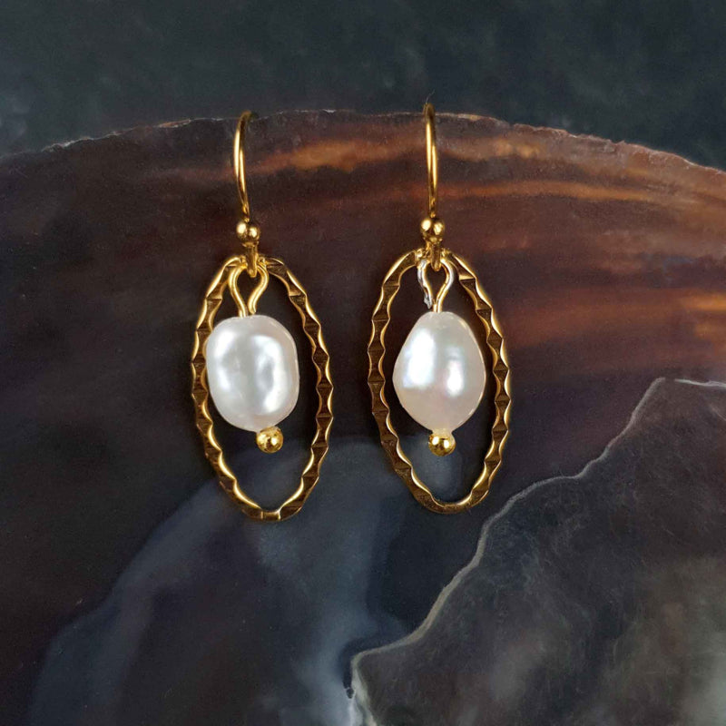 Witte zoetwater parel oorbellen met goud edelstaal liggend in schelp | Oda
