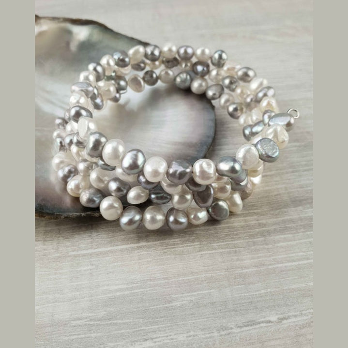 Zoetwater parel armband met witte en grijze parels liggend tegen schelp | Zen White Grey