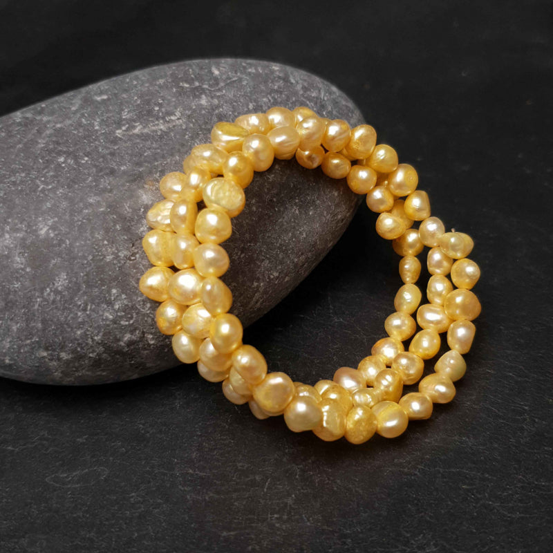 Zoetwater parel wikkel armband met gele parels liggend tegen kei | Zen Yellow